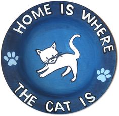 a blue plate with a cat on it that says home is where the cat is