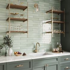 a kitchen with green cabinets and shelves filled with wine glasses, plates and other items