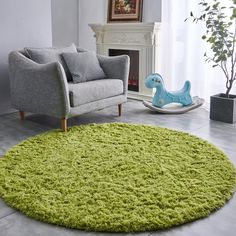 a living room with a green rug on the floor and a gray couch in front of it