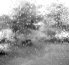 black and white photograph of rain drops on window