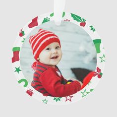 a christmas ornament with an image of a baby wearing a red and green hat