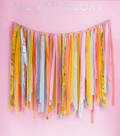 colorful streamers hanging from a pink wall with the words all her glory on it