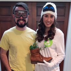 a man and woman standing next to each other in front of a door holding plants