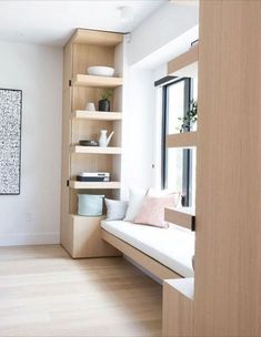 a living room filled with furniture and bookshelves next to a wall mounted art piece