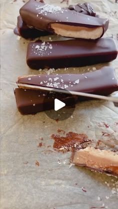 three pieces of chocolate on a piece of parchment paper with a knife in the middle