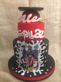 a three tiered cake with anime characters on the top and bottom layer is red, black, and white