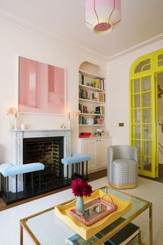 a living room filled with furniture and a fire place in front of a book shelf