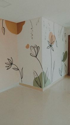 an empty room with flowers painted on the wall and flooring in front of it