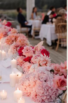 a long table with flowers and candles on it