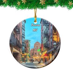 a christmas ornament with a painting of a city street and people walking on the sidewalk