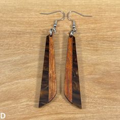 New item for 2023! Look stylish with these Acrylic and Koa Wood Earrings featuring mocha pearl acrylic and endemic Hawaiian Koa wood. Textured and lightweight, they're easy to wear and sure to stand out. Why not add a special touch to your outfit while making a statement? Crafted in Hawaii with cast acrylic and endemic Hawaiian Koa wood from the Big Island of Hawaii. Features: * Color: Mocha Pearl* Length: 2 1/4 inches* Drop length: 3 3/8 inches* Width: 7/16 inches* Light weight* Hypoallergenic Big Island Of Hawaii, Island Of Hawaii, Koa Wood, The Big Island, Cast Acrylic, Hawaii Island, Wood Earrings, Big Island, Wire Jewelry