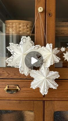 an origami snowflake hanging from a wooden cabinet