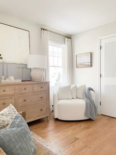 a living room with white furniture and wood floors