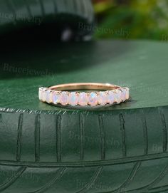 a pink opal ring sitting on top of a green surface