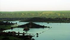 a large body of water surrounded by lush green hills