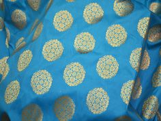 Turquoise Brocade by the Yard Fabric Wedding Dresses Banarasi Fabric Banaras Blended silk Brocade costume fabric lehenga Skrit Fabric. This is a beautiful banarasi blended silk brocade mandala design fabric in Turquoise Blue and Gold. ➤Product: Brocade Fabric ➤Fabric Type: Blended Silk (Viscose and Silk) Fine quality Zari Brocade Weaving from Banaras ➤Color: Turquoise Blue and Gold ➤Width: 44 inches. ➤Condition: New ➤Code: bg491 ➤Listing for 1 Yard of fabric. ➤Care: Dry Clean Only You can use th Blue Festive Ceremonial Lehenga, Blue Silk Lehenga With Zari Weaving, Traditional Blue Embroidered Fabric With Self Design, Blue Anarkali Dupatta For Ceremonial Occasions, Blue Jamawar Lehenga For Eid, Eid Blue Brocade Lehenga, Blue Brocade Lehenga For Eid, Traditional Blue Embroidered Self-design Fabric, Blue Jamawar Anarkali Set For Wedding