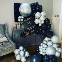 black and white balloons are arranged in the shape of an arch for a balloon display