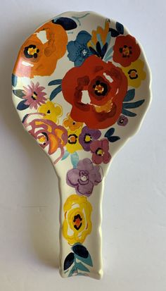 a colorful flowered ceramic hair brush on a white background