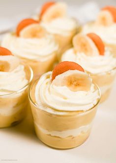 small desserts with bananas and whipped cream in glass cups on a white tablecloth