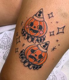 two pumpkins with hats on their heads are sitting next to each other in front of a woman's leg