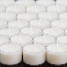 several rows of white candles sitting on top of each other