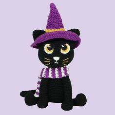 a crocheted black cat wearing a purple hat and scarf