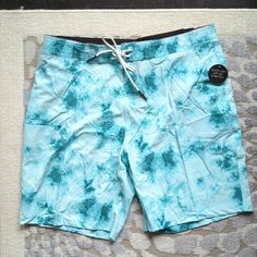 Bay Blue Color In A Tie Dye Pattern. Size 38 Inch Waist. The Ultimate Boardshorts From No Boundariesperfect For Splashing Around At The Beach, Lake, Water Park, Pool And Beyond! These Men's Boardshorts Are Designed With 4-Way Stretch Performance Fabric And Quick-Dry And Upf 50 Sun Protection Properties. These Swim Trunks Are Stretchy, Comfortable And Ready For Year-Round Fun Featuring A Fixed Waist, Front Tie Closure And An Unlined Design. Material: 90% Polyester/10% Elastane Fit: Relaxed Rise A Blue Fitted Shorts For Pool, Fitted Blue Shorts For Pool, Blue Fitted Surfing Shorts, Blue Swimwear With Pockets For Surfing, Fitted Blue Surfing Shorts, Light Blue Fitted Shorts For Beach, Blue Shorts With Pockets For Poolside, Short Blue Bottoms For Surfing, Blue Shorts For Surfing