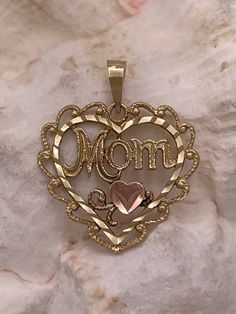 Vintage 14k solid gold Mom heart charm pendant  A lovely gift for a special mom! This delicate and detailed charm pendant is crafted in pure 14k yellow gold and features an elegant open heart design.  Inside the heart, the fancy grooved lettering is accented by a tiny little rose gold heart and a few filigree sprigs.  The tiny rose gold heart has a brushed finish and is diamond-cut.   The narrow frame of the open heart features a diamond-cut finish which catches the light beautifully.  Textured 14k Gold Charms For Valentine's Day Gift, Elegant Charms For Anniversary And Mother's Day, Mother's Day Heart Pendant Charms, Valentine's Day Gift Charms In Yellow Gold, Mother's Day Charms For Mom, Mother's Day Charms Gift For Mom, Mother's Day Gift For Mom Charms, Hallmarked Jewelry For Mother's Day, Gold Charms For Anniversary And Mother's Day