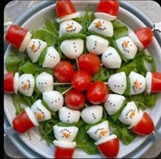 a white plate topped with tomatoes and marshmallows on top of lettuce