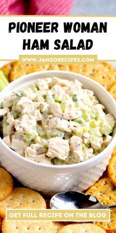 a white bowl filled with chicken salad surrounded by crackers