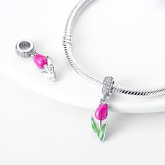 925 Sterling Silver dangle charm featuring a tulip, designed with smooth pink and green enamel and white and pink sparkling zircon gemstones. Tulips symbolize pure and unconditional love. Tell your story with each charm and create a bracelet that reflects who you are and what's important to you. Your style. Your bracelet. Your story. Features: Material: 925 Sterling Silver, Zircon, EnamelDesign: Pink Tulip Dimensions: 2.3 x 0.7 cm / 0.92" x 0.27"Fits 0.3 cm / 0.1" BraceletsCollection: Flowers Shipping Info: United States / Canada / Australia: 10 - 15 daysEurope: 10 - 15 daysUAE: 17 daysOther Countries: 20 - 40 days Hassle Free Returns: If you are not completely satisfied with your purchase, you can send it back to us for a refund. Sterling Silver Pink Charms Jewelry, Pink Sterling Silver Charms For Mother's Day, Pink Sterling Silver Charms For Gifts, Pink Dangling Charms For Mother's Day, Pink Charms For Mother's Day, Elegant Sterling Silver Pink Charms, Pink Sterling Silver Charms For Valentine's Day, Pink Sterling Silver Charm Bracelet With Dangling Charms, Sterling Silver Pink Charm Bracelet With Dangling Charms