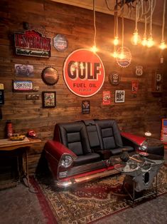 a living room filled with furniture and lots of lights hanging from the ceiling next to a wooden wall