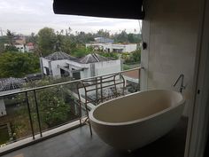 a bath tub sitting on top of a balcony next to a window