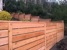 several wooden planters are lined up on the side of a fenced in area