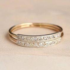 two gold wedding bands with diamonds on them