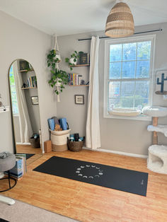 a cat tree in the corner of a room with a rug on the floor next to it