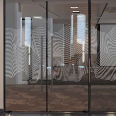 an office building with glass doors that have wavy lines drawn on the glass to make it look like waves