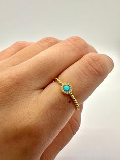 This is a lovely opal Ring with beautiful details. It features a round opal cabochon surrounded by dazzling simulated diamonds to add a little extra bling and beauty. The beaded band goes around the ring completely for an added layer of detail and charm. Choose between a white or blue opal. Either option gives off a beautiful play of color.  ~ 925 Stamped ~ 14K Gold over  ~ Synthetic Opal Center Stone White or Blue ~ High-quality simulated diamonds surrounding  How to care for your gold plated s Adjustable Opal Ring Birthstone With Round Stone, Round Opal Jewelry With Halo Detail, Opal Halo Jewelry With Round Shape, Halo Opal Jewelry With Round Shape, Adjustable Gold Opal Ring, Gold Adjustable Opal Ring, Round Shape, Gold Opal Ring Adjustable, Opal Round Band Ring For Gift, Opal Ring Gift