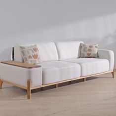 a white couch sitting on top of a hard wood floor next to a wooden table