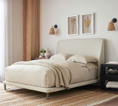 a white bed sitting in a bedroom on top of a wooden floor