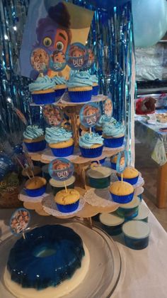 cupcakes are arranged in the shape of a tree on top of a table