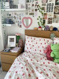 a bed with pink and green stuffed animals on it's covers in a bedroom