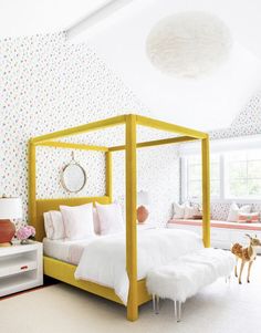 a bedroom with white bedding and yellow frame