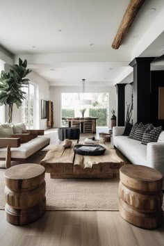 a living room filled with furniture and a wooden table in front of a large window