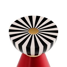 a black and white striped object sitting on top of a red stand with gold accents