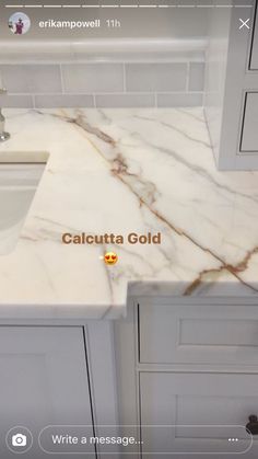 a white marble counter top sitting next to a sink in a bathroom under a faucet