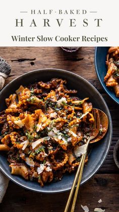 a bowl filled with pasta and meat on top of a wooden table next to other bowls