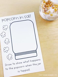 a card that says popcorn in salt on a table next to a jar of candy