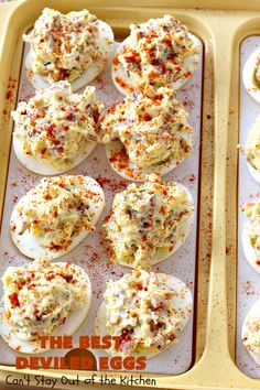 deviled eggs are stuffed with cheese and seasoning in a baking pan on a table