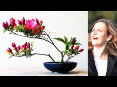 a woman standing next to a vase with flowers in it and an image of a plant